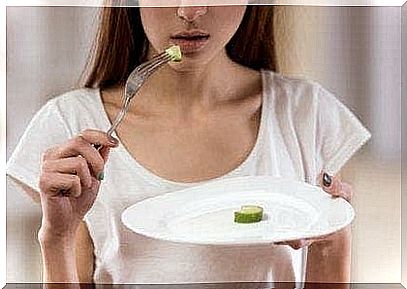 A woman shows a plate with little food on it