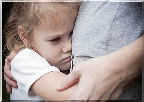 A girl clings to one of her parents