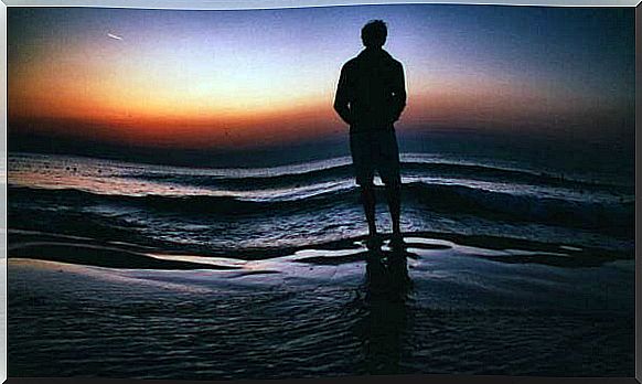 Man standing on a beach because one of the hallmarks of emotional maturity is thinking about your future