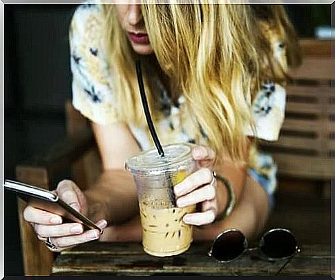 Girl with iced coffee and cellphone