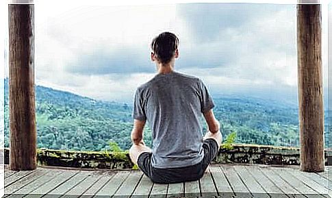 A man meditates and looks out over mountains