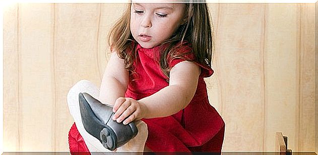 A little girl putting on her shoes