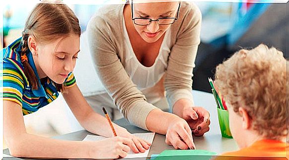 A teacher helping two students