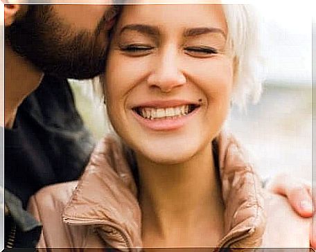 A man kisses a woman on the cheek