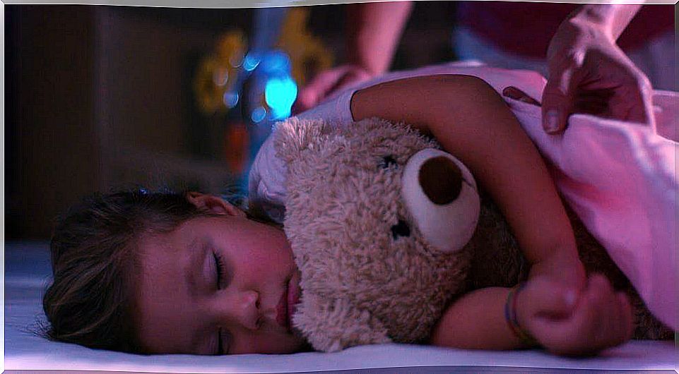 Girl dreaming with her teddy bear in her arms